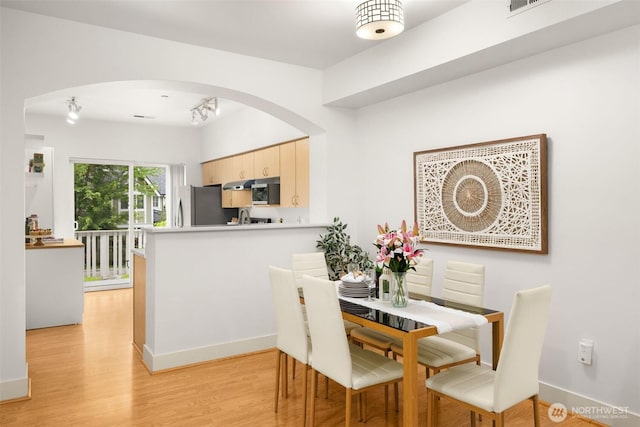 18223 NE 95th Way Unit 102, Redmond, WA 98052 - dining space with arched walkways and light wood-type flooring