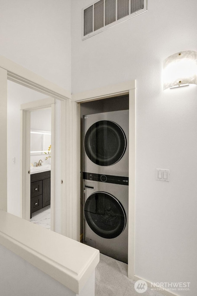 18223 NE 95th Way Unit 102, Redmond, WA 98052 - laundry room featuring stacked washing machine and dryer and light carpet