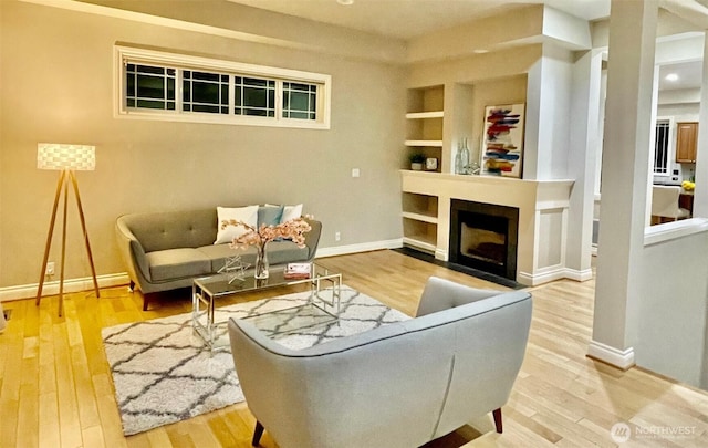 6802 156th Pl NE, Redmond, WA 98052 - living room featuring wood finished floors, built in shelves, and a fireplace
