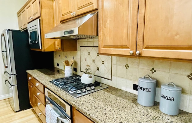 6802 156th Pl NE, Redmond, WA 98052 - kitchen featuring appliances with stainless steel finishes, under cabinet range hood, light stone countertops, and decorative backsplash