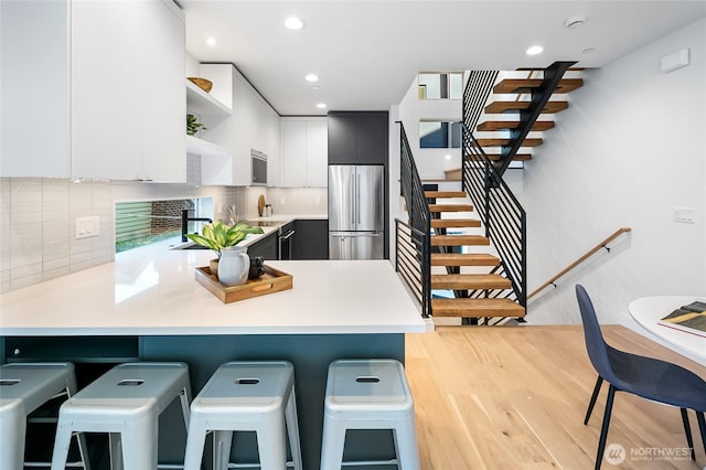 2009B Dexter Ave N, Seattle, WA 98109 - kitchen featuring stainless steel refrigerator, open shelves, a peninsula, light countertops, and modern cabinets