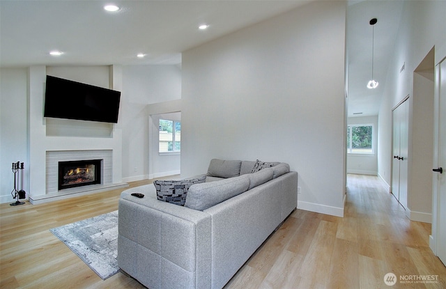 1611 NE 113th St Unit 421, Vancouver, WA 98686 - living room with healthy amount of natural light, light wood-style floors, a warm lit fireplace, recessed lighting, and high vaulted ceiling