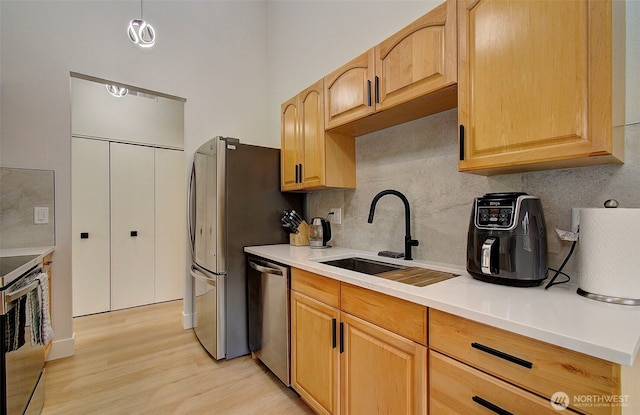 1611 NE 113th St Unit 421, Vancouver, WA 98686 - kitchen featuring appliances with stainless steel finishes, backsplash, light wood-type flooring, and light countertops