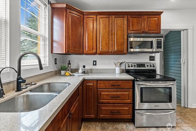 820 S Ferry St, Tacoma, WA 98405 - kitchen featuring appliances with stainless steel finishes, light stone countertops, and brown cabinets