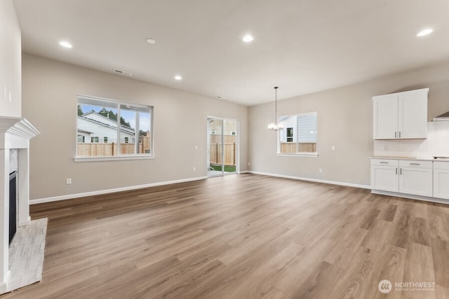 5801 SW Thornhill Ave SW Unit 323, Port Orchard, WA 98367 - unfurnished living room with a fireplace, a chandelier, light wood finished floors, and recessed lighting