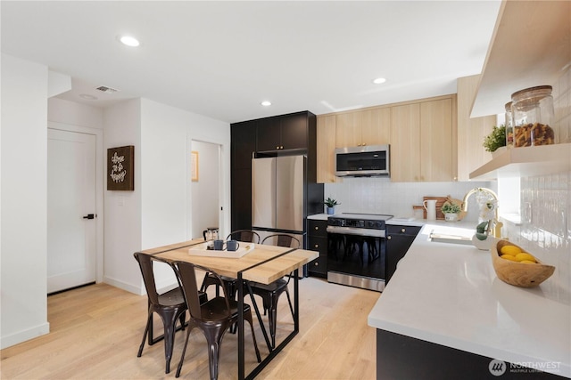 826 NE 95th St, Seattle, WA 98115 - kitchen with electric range oven, stainless steel microwave, freestanding refrigerator, light countertops, and light wood finished floors
