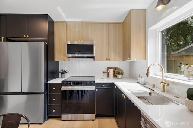 826 NE 95th St, Seattle, WA 98115 - kitchen with stainless steel appliances, light countertops, decorative backsplash, light wood-type flooring, and light brown cabinetry