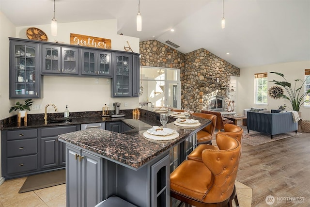 43936 SE 127th Pl, North Bend, WA 98045 - kitchen featuring vaulted ceiling, open floor plan, gray cabinets, a kitchen bar, and glass insert cabinets