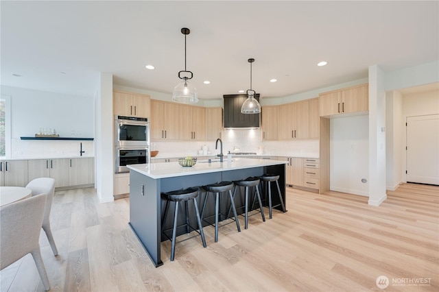 30408 SE 304th St, Auburn, WA 98038 - kitchen with light brown cabinetry, double oven, light wood-type flooring, a breakfast bar, and recessed lighting