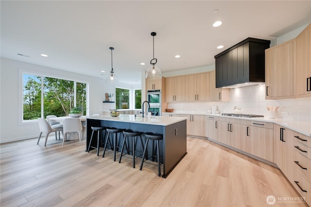 30408 SE 304th St, Auburn, WA 98038 - kitchen with light brown cabinets, a kitchen bar, modern cabinets, light wood-style floors, and recessed lighting
