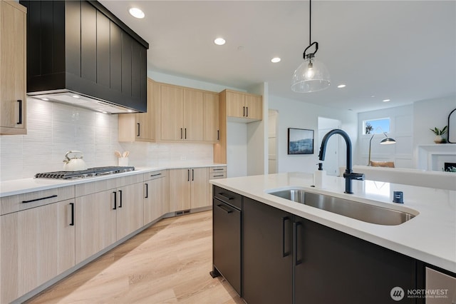 30408 SE 304th St, Auburn, WA 98038 - kitchen with light brown cabinetry, stainless steel gas stovetop, premium range hood, light countertops, and tasteful backsplash