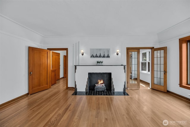 519 W Roy St Unit 211, Seattle, WA 98119 - unfurnished living room with wood finished floors, a fireplace with flush hearth, crown molding, and french doors