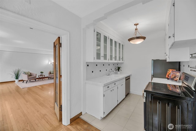 519 W Roy St Unit 211, Seattle, WA 98119 - kitchen with appliances with stainless steel finishes, light countertops, white cabinets, glass insert cabinets, and light wood finished floors