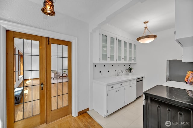 519 W Roy St Unit 211, Seattle, WA 98119 - kitchen with appliances with stainless steel finishes, light countertops, white cabinetry, french doors, and glass insert cabinets