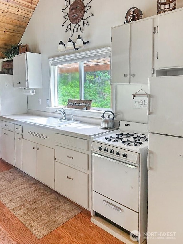 6 Lone Pine Trl, Riverside, WA 98849 - kitchen with white appliances, wooden ceiling, light countertops, vaulted ceiling, and white cabinetry