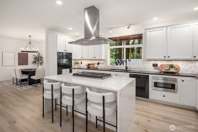 16432 SE 24th St, Bellevue, WA 98008 - kitchen featuring black appliances, island exhaust hood, a kitchen breakfast bar, a kitchen island, and decorative backsplash