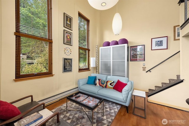 842 Washington St Unit 204, Port Townsend, WA 98368 - living area featuring a baseboard radiator, healthy amount of natural light, wood finished floors, and stairway