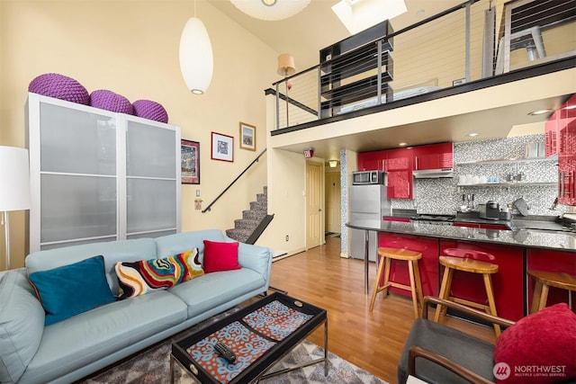 842 Washington St Unit 204, Port Townsend, WA 98368 - living room with light wood-type flooring, stairs, and a high ceiling