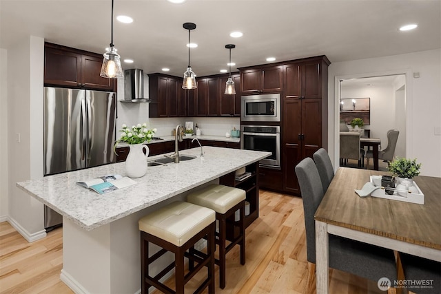 12810 SE 22nd Pl, Bellevue, WA 98005 - kitchen with stainless steel appliances, wall chimney range hood, dark brown cabinetry, light wood-type flooring, and a breakfast bar area