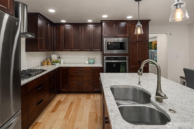 12810 SE 22nd Pl, Bellevue, WA 98005 - kitchen featuring appliances with stainless steel finishes, light wood-style flooring, backsplash, hanging light fixtures, and recessed lighting