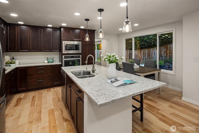 12810 SE 22nd Pl, Bellevue, WA 98005 - kitchen with stainless steel appliances, light wood-type flooring, decorative light fixtures, recessed lighting, and dark brown cabinetry