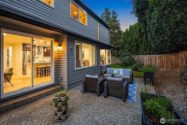 12810 SE 22nd Pl, Bellevue, WA 98005 - patio terrace at dusk with an outdoor hangout area, a fenced backyard, and a patio