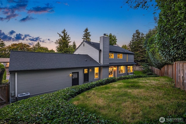 12810 SE 22nd Pl, Bellevue, WA 98005 - back of property at dusk with a fenced backyard and a chimney