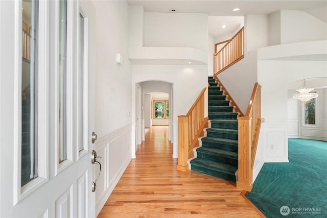 2804 18th St SE, Puyallup, WA 98374 - foyer featuring arched walkways, light wood-style floors, stairs, a chandelier, and a towering ceiling