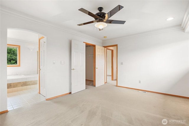 2804 18th St SE, Puyallup, WA 98374 - unfurnished bedroom featuring crown molding, arched walkways, light colored carpet, ensuite bath, and a spacious closet