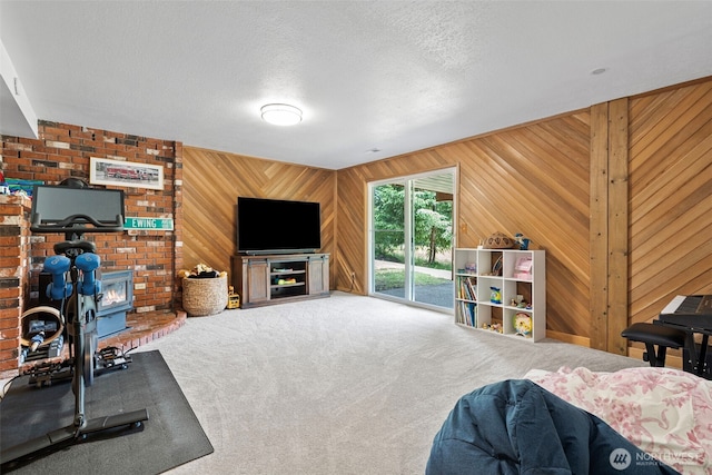6511 Canyon Ct SW, Olympia, WA 98512 - living area with carpet floors, a wood stove, wood walls, and a textured ceiling
