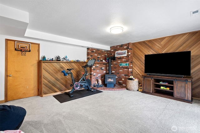 6511 Canyon Ct SW, Olympia, WA 98512 - workout area with wooden walls, carpet flooring, and a wood stove