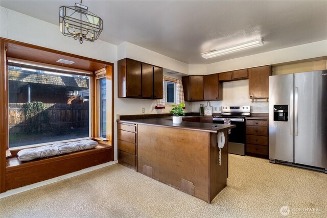 913 Woodlawn, Walla Walla, WA 99362 - kitchen with stainless steel appliances, dark countertops, a peninsula, light colored carpet, and dark brown cabinetry