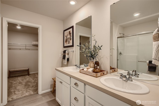 14029 195th Street Ct E, Graham, WA 98338 - full bathroom with wood finished floors, double vanity, a walk in closet, a shower with door, and recessed lighting