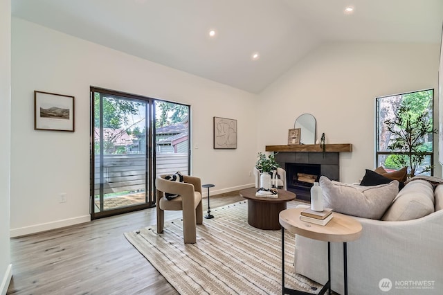 12200 100th Ave NE Unit N-D, Kirkland, WA 98034 - living room with vaulted ceiling, a tiled fireplace, light wood-style floors, and recessed lighting