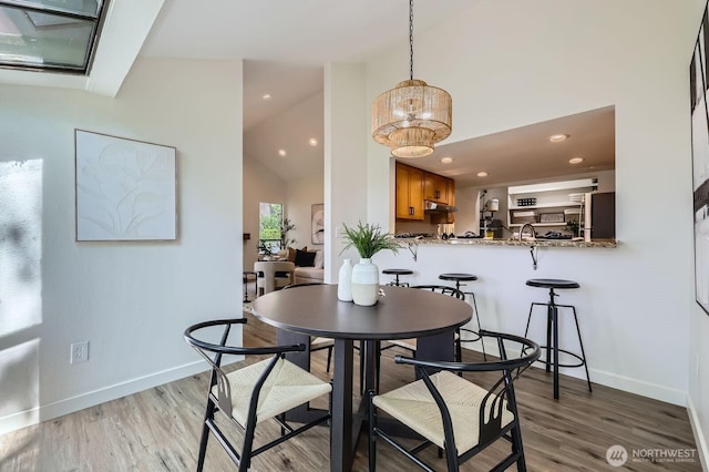 12200 100th Ave NE Unit N-D, Kirkland, WA 98034 - dining space featuring light wood finished floors, a chandelier, high vaulted ceiling, and recessed lighting