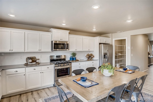 19707 140th Avenue Ct E, Graham, WA 98338 - kitchen featuring stainless steel appliances, white cabinets, light wood-style floors, and recessed lighting