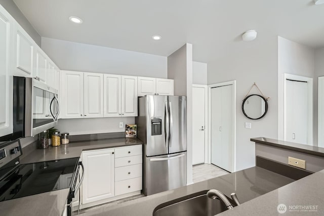 2414 1st Ave Unit 519, Seattle, WA 98121 - kitchen featuring stainless steel appliances, white cabinetry, dark countertops, and recessed lighting