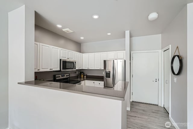 2414 1st Ave Unit 519, Seattle, WA 98121 - kitchen featuring stainless steel appliances, light wood finished floors, white cabinets, a peninsula, and recessed lighting