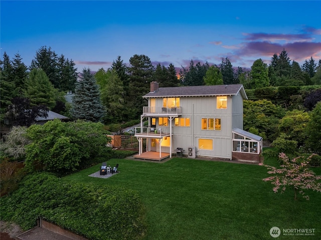 11665 NE Sunset Loop, Bainbridge Island, WA 98110 - back of house at dusk with a balcony, a chimney, an outdoor fire pit, and roof with shingles