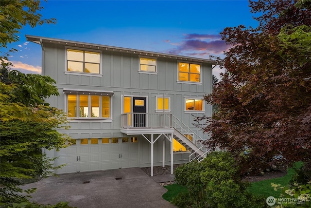 11665 NE Sunset Loop, Bainbridge Island, WA 98110 - view of front facade featuring stairway, board and batten siding, a garage, and concrete driveway