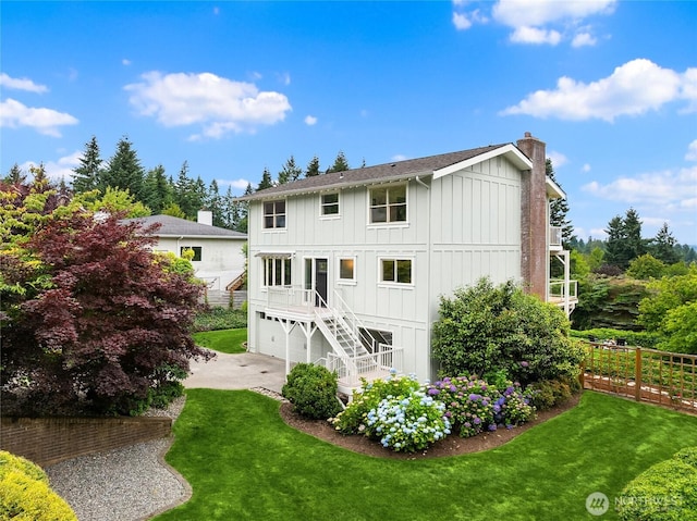 11665 NE Sunset Loop, Bainbridge Island, WA 98110 - back of property with board and batten siding, a chimney, stairs, driveway, and a garage