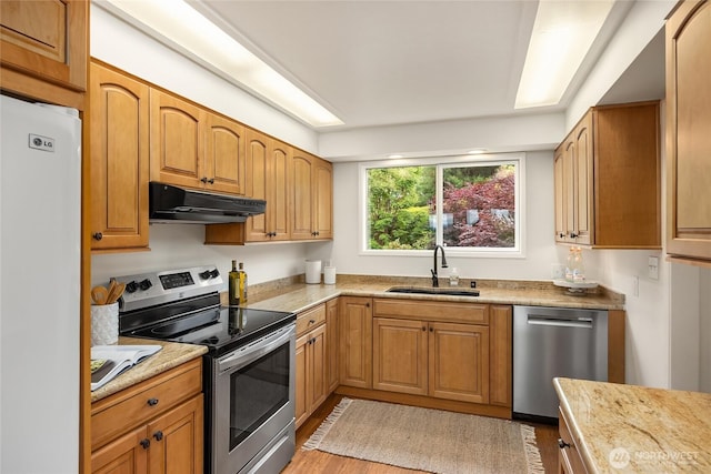 11665 NE Sunset Loop, Bainbridge Island, WA 98110 - kitchen with stainless steel appliances, under cabinet range hood, light wood finished floors, and light stone countertops