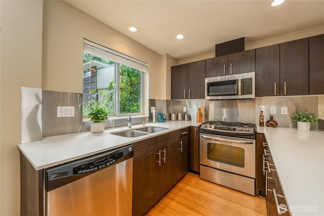 3926A S Brandon St, Seattle, WA 98118 - kitchen featuring appliances with stainless steel finishes, recessed lighting, light countertops, dark brown cabinetry, and light wood-type flooring