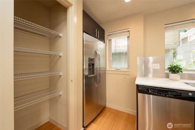 3926A S Brandon St, Seattle, WA 98118 - kitchen with stainless steel appliances, light wood-style flooring, healthy amount of natural light, and light countertops