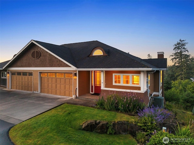 3224 Overlook Loop, Ilwaco, WA 98624 - view of front of home featuring an attached garage, a chimney, concrete driveway, and a front lawn