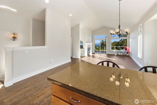 3224 Overlook Loop, Ilwaco, WA 98624 - kitchen featuring dark wood-type flooring, a chandelier, open floor plan, dark stone counters, and vaulted ceiling