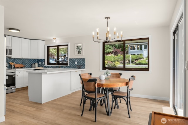 21239 15th Ave S, Des Moines, WA 98198 - dining space featuring a chandelier and light wood-style floors