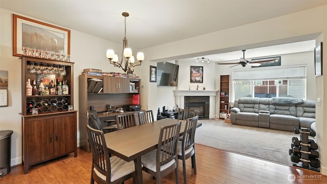 4650 NE 3rd Ln Unit F1, Renton, WA 98059 - dining room with light wood-style floors, a glass covered fireplace, ceiling fan, and a chandelier
