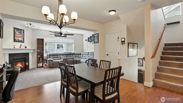4650 NE 3rd Ln Unit F1, Renton, WA 98059 - dining space featuring light wood-style flooring, a chandelier, ceiling fan, a glass covered fireplace, and stairway