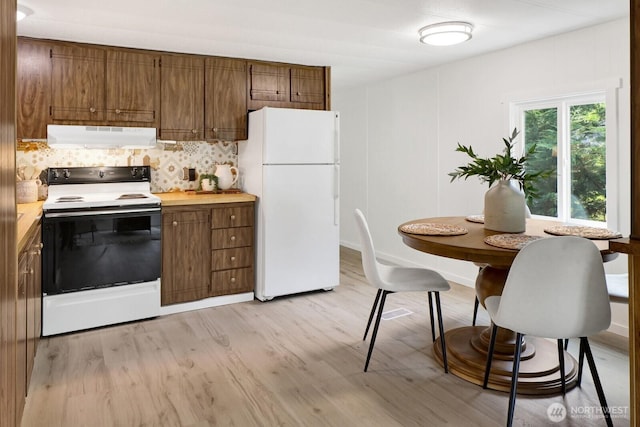 6219 Shamrock Rd, Maple Falls, WA 98266 - kitchen featuring white appliances, under cabinet range hood, brown cabinetry, and light countertops